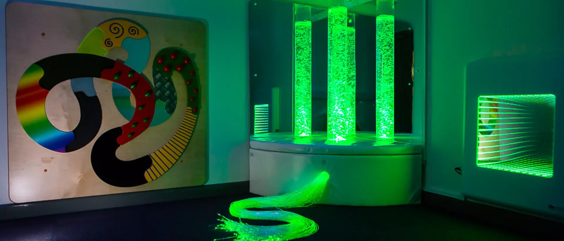 The sensory room in Hamad Airport featuring green LED bubble tubes.