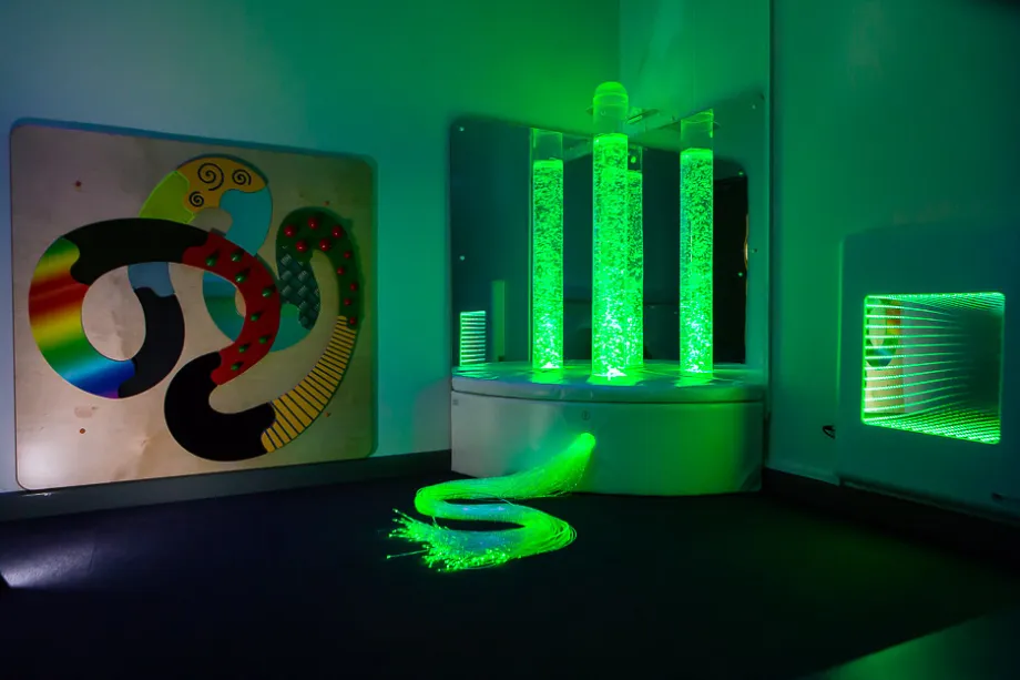 The sensory room in Hamad Airport featuring green LED bubble tubes.